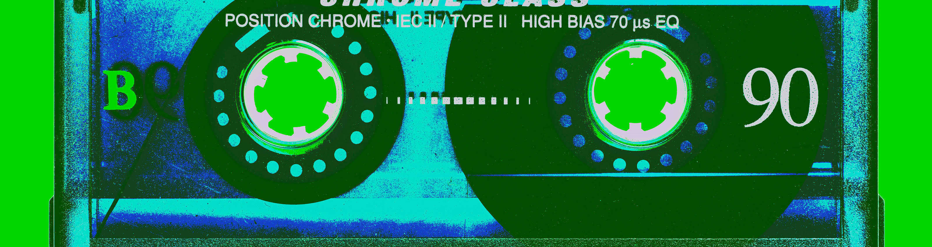 A stylized image of a cassette tape with visible reels and text, set against a bright green background.